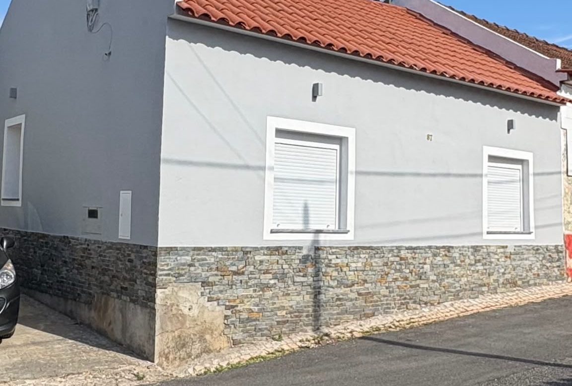 Fachada de moradia com pintura e soco em pedra novos